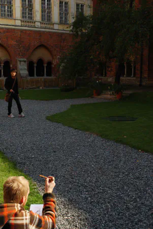 Someone drawing one of the windows in the square behind Dome cathedral