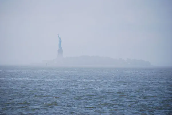 The Statue of Liberty in the mist seen from Battery Park